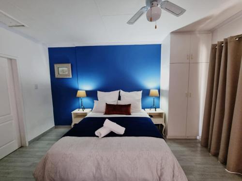 sypialnia z dużym łóżkiem z niebieską ścianą w obiekcie The Noble Dew Guest House w mieście Newcastle