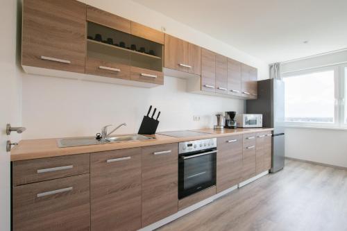 a kitchen with wooden cabinets and a sink at T&K Apartments Comfortable 3 Room Apartments with Balcony in Duisburg