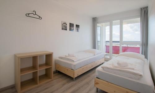 2 camas en una habitación con ventana en T&K Apartments Comfortable 3 Room Apartments with Balcony, en Duisburg