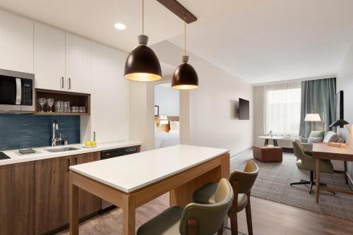 an open kitchen and living room with a table and chairs at Staybridge Suites Rochester - Mayo Clinic Area by IHG in Rochester
