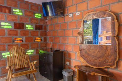 uma parede de tijolos com um espelho e uma cadeira de madeira em Hotel Luna Llena em Mariquita