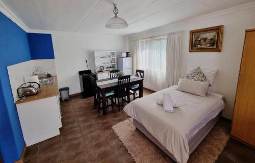 a bedroom with a bed and a kitchen with a table at The Noble Dew Guest House in Newcastle