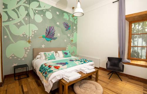 a bedroom with a bed and a wall with butterflies at Solar Madariaga Hotel in Vicuña