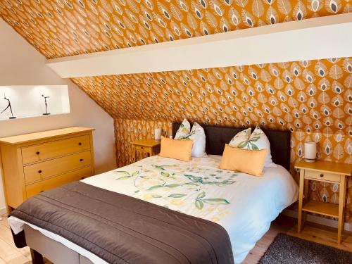 a bedroom with a large bed and a wooden wall at Le Clos des Marronniers in Douvres-la-Délivrande