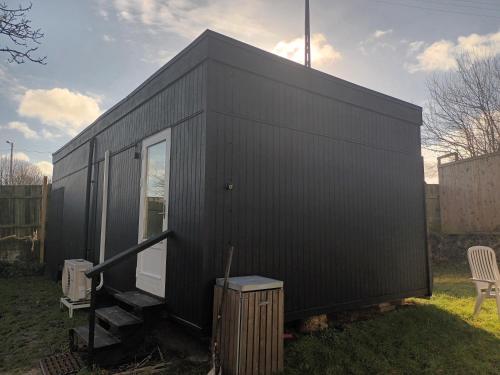 a black tiny house in a yard at Bonjour Copenhagen in Herlev