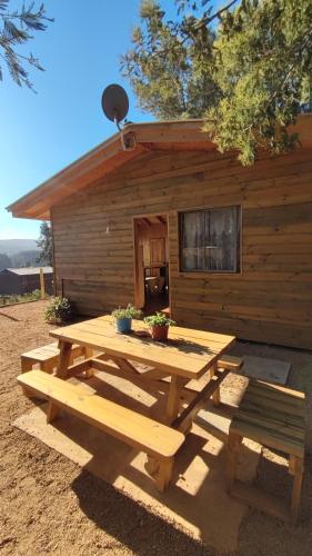 a picnic table in front of a cabin at Casa Atardecer Vichuquén in Vichuquén