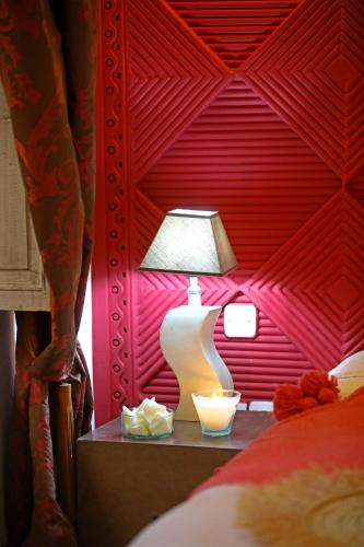 a lamp on a table next to a bed at Riad Anyssates in Marrakech