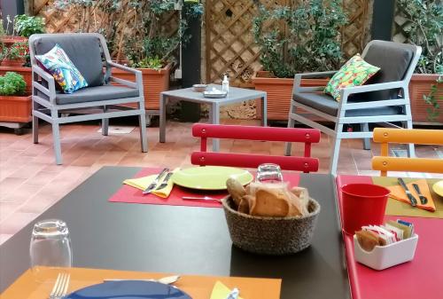 a table and chairs on a patio with a table at La Foresteria Garden Boutique B&B in Catania