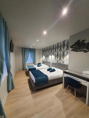 ein Hotelzimmer mit 2 Betten und einem Schreibtisch in der Unterkunft New Windsor in Étretat