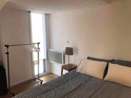 1 dormitorio con 1 cama y TV en Logement neuf avec jardin privé 4 couchages Option piscine, en Les Iffs