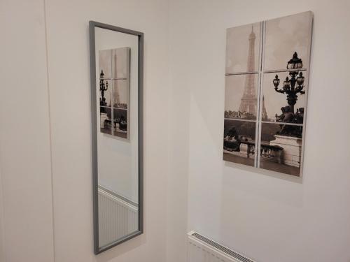 a mirror on a wall with pictures of the eiffel tower at Coed Helen Holiday Park in Caernarfon