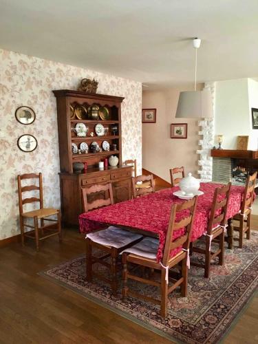 a dining room with a red table and chairs at La grande maison de Carrouges in Carrouges