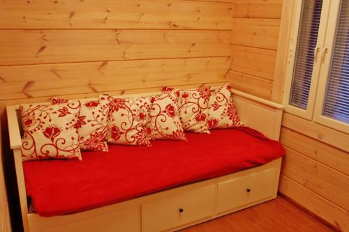 1 cama con almohadas rojas y blancas en una habitación en SaimaanHelmi en Savonlinna