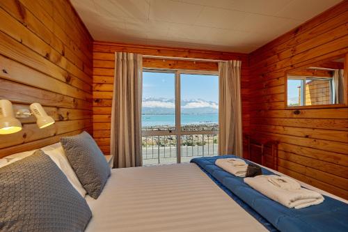 a bedroom with a bed with a view of the ocean at Panorama Motel in Kaikoura