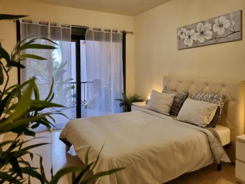 um quarto com uma cama e uma grande janela em Marbella Luxury Fast Internet Netflix em Estepona