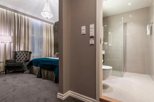 a bathroom with a bed and a toilet and a shower at Home Hotel Grand Gjøvik in Gjøvik