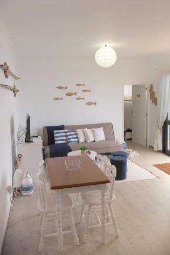 a living room with a table and a couch at Casa Azul - Ocean View in Porto Moniz