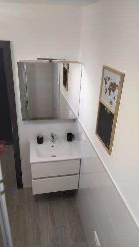 a white bathroom with a sink and a mirror at Apartments Dora 2 in Bibinje
