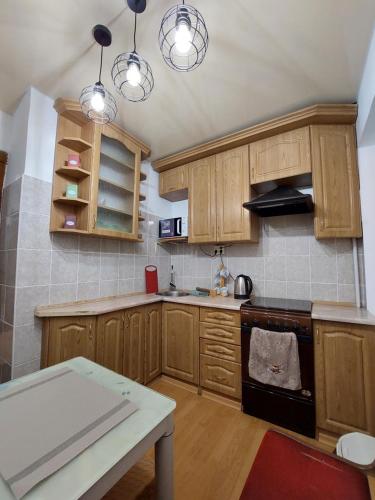 a kitchen with wooden cabinets and a stove top oven at Подобова оренда двокімнатної квартири Старичі in Starychi