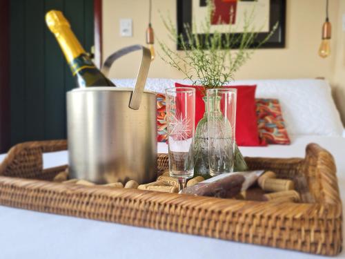 uma cesta com uma garrafa de vinho e copos sobre uma mesa em Estúdio Amor: refúgio à dois nas montanhas em Lavras Novas