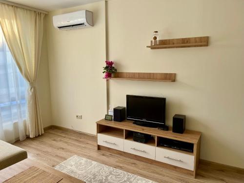 a living room with a flat screen tv on a cabinet at Pirin Dream View Apartments in Razlog