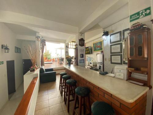 a bar in a restaurant with stools at Hostal Isla Señorial in San Gil