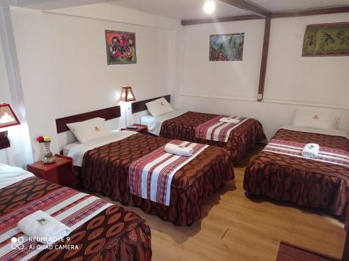 a hotel room with three beds in a room at DENNY'S MAPI in Machu Picchu