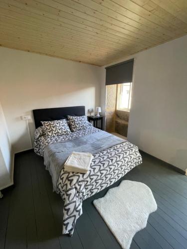 - une chambre avec un lit et une couette noire et blanche dans l'établissement Casa Tania, à Ligonde