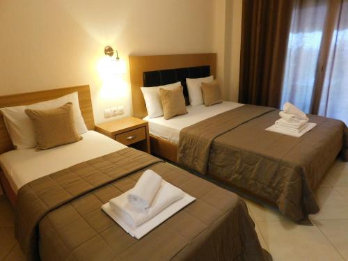 a hotel room with two beds with towels on them at Anna House 2 in Sarti