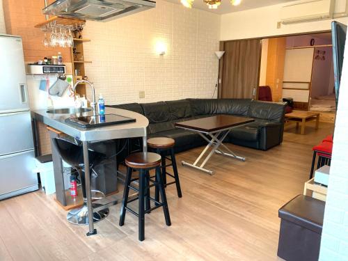 a kitchen and living room with a couch and a table at YokohamaKannai HouseBar in Yokohama
