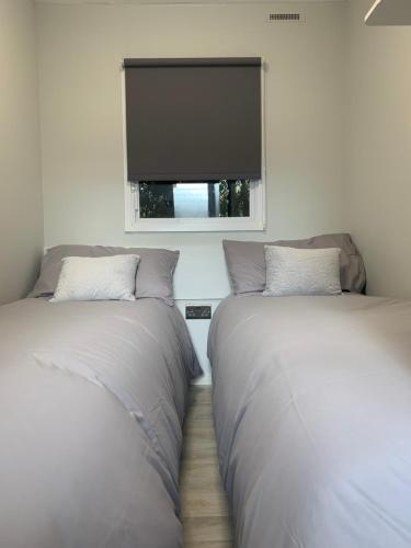 two beds in a room with a flat screen tv at Beautiful Holiday Home - Lake view in York