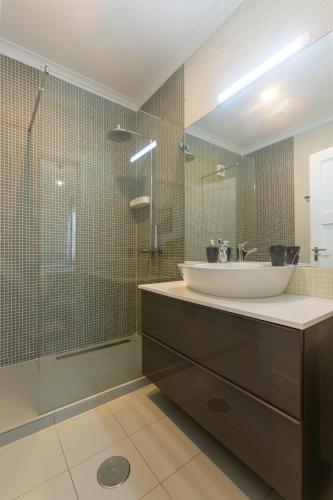 a bathroom with a sink and a glass shower at My Angra Charming House in Angra do Heroísmo