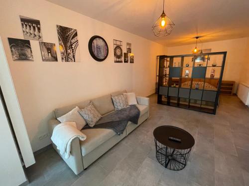 ein Wohnzimmer mit einem Sofa und einem Tisch in der Unterkunft Appartement avec extérieur à proximité de Liège in Herstal