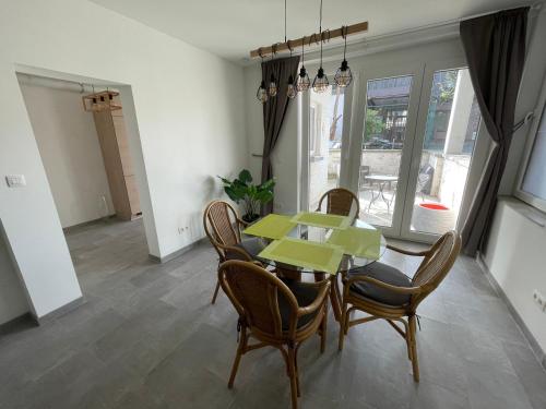 a dining room with a green table and chairs at Appartement avec extérieur à proximité de Liège in Herstal