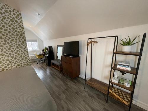 a bedroom with a bed and a tv and a shelf at The Archie & Isidore Hotel in Chéticamp