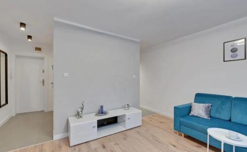salon z niebieską kanapą i stołem w obiekcie Mieszkanie Spokojny Sopot w mieście Sopot