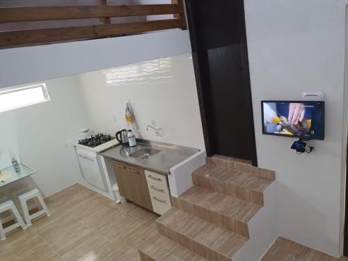 a kitchen with a sink and a tv on a wall at Pousada Korb in Santo Amaro da Imperatriz
