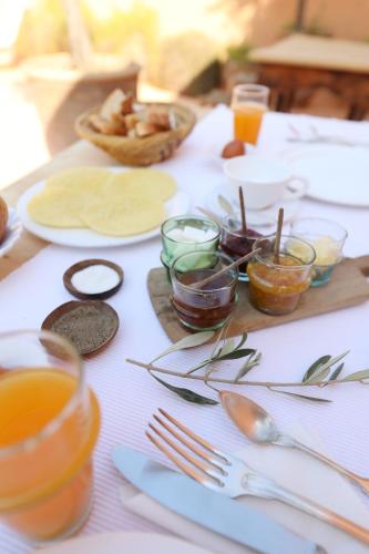 a white table with utensils and plates of food at Riad Azzouna 13 in Marrakech