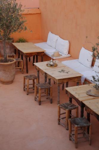 a room with wooden tables and white couches at Riad Azzouna 13 in Marrakech