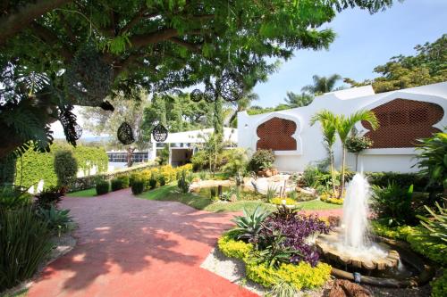 a garden with a fountain in front of a house at Villa Bejar Cuernavaca in Cuernavaca