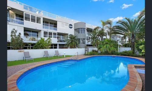 a large swimming pool in front of a large building at Sundeck Gardens in Maroochydore