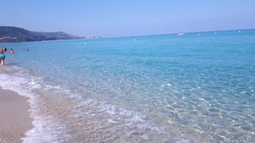 a group of people walking on the beach at Appartamenti Comfort in Mandaradoni