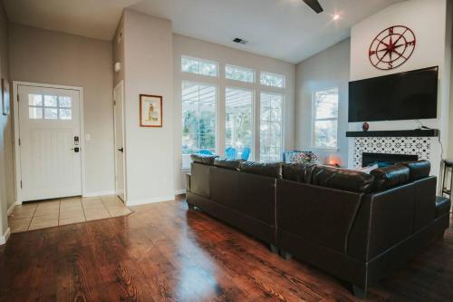 a living room with a leather couch and a fireplace at Central Coziness - Steps from Chico's Hub in Chico