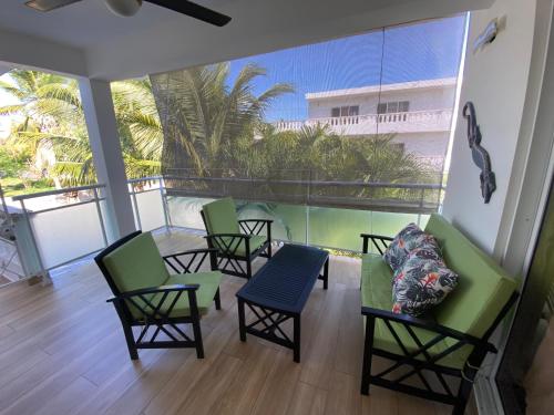 a balcony with chairs and a couch and a table at Diamond Hotel Cabarete in Cabarete