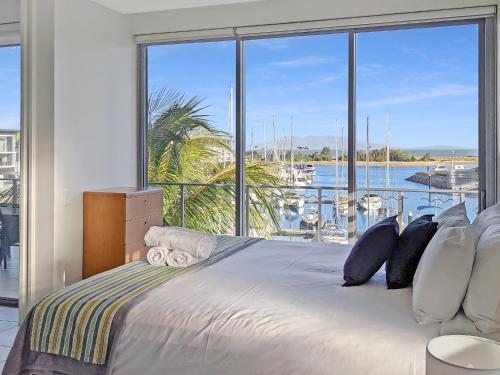 a bedroom with a large bed with a large window at Blue on Blue Apartment 932 in Nelly Bay