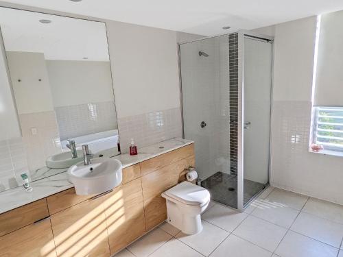 a bathroom with a toilet and a sink and a shower at Blue on Blue Apartment 932 in Nelly Bay