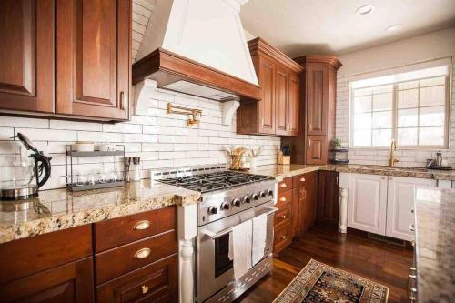a kitchen with wooden cabinets and a stove top oven at *Spacious, Modern Mountain Vacation Home!* in Provo