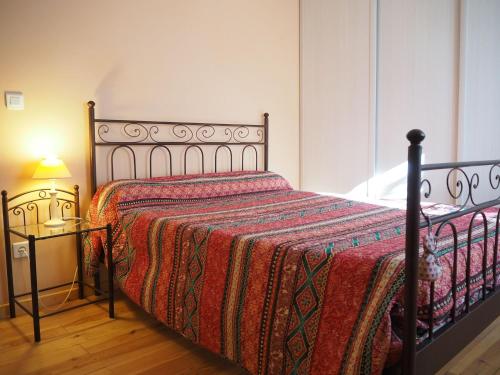 1 dormitorio con 1 cama con manta roja y lámpara en Holiday home, Villemagne-l'Argentière, en Villemagne