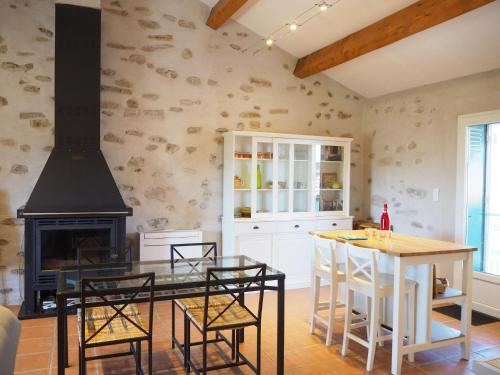 une cuisine avec une cheminée, une table et des chaises dans l'établissement Country House in Orb Mountains near Salagou Lake, à Villemagne
