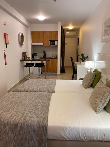a hotel room with two beds and a kitchen at Esmeralda Holidays Apartments in Funchal